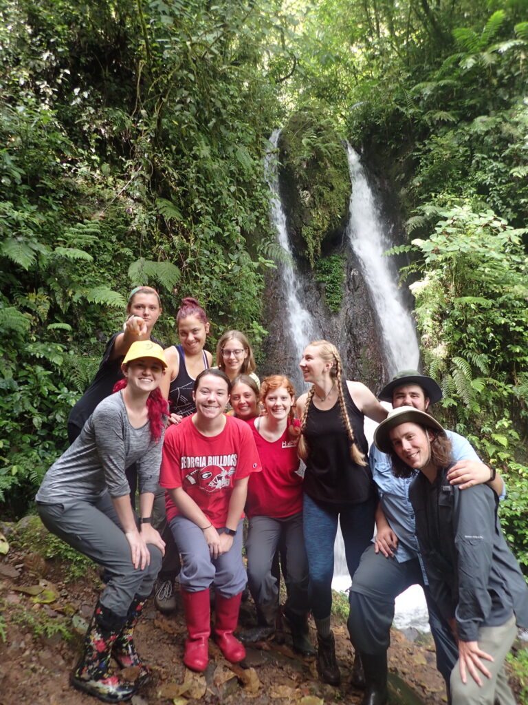 student group with waterfall in background
